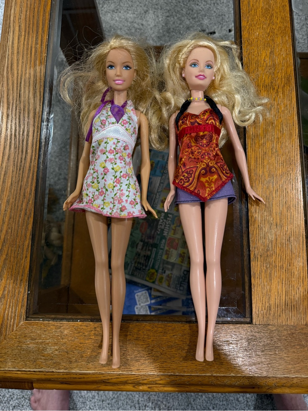 two blonde Mattel Barbie dolls with different facial expressions and outfits.